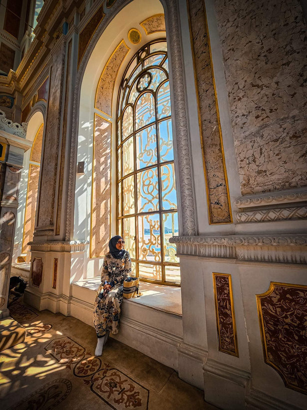 Istanbul, Turkiye - a woman sitting in front of a large window in Ortakoy Grand Mosque