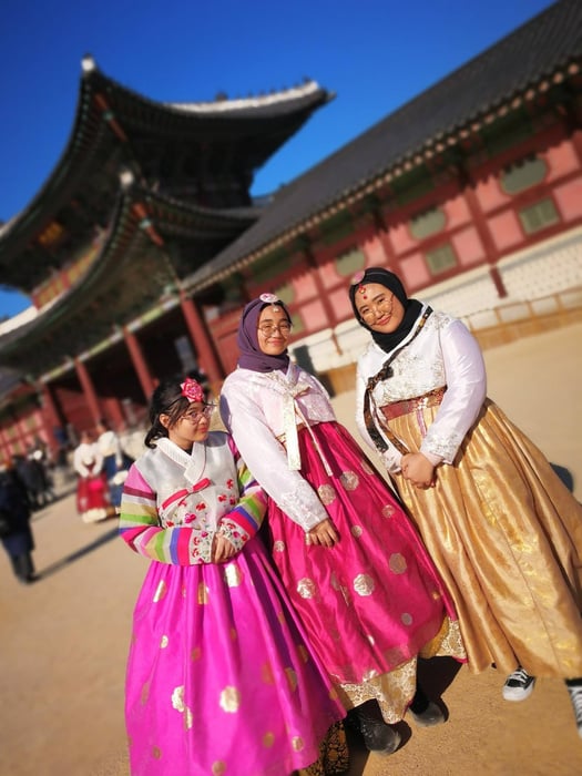 Seoul, South Korea - three individuals dressed in traditional hanbok pose for the camera at Gyeongbokgung Palace