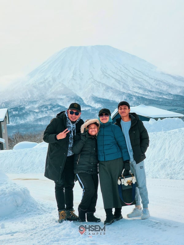 Hokkaido, Japan - four Malaysian pose for a photo in front of a mountain (Mount Yotei)